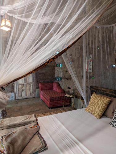 a bedroom with a bed with a mosquito net at Backyard Hostel in Moshi