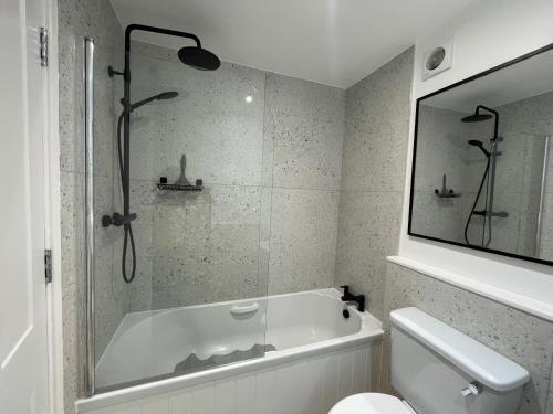 een badkamer met een bad en een toilet bij Modern and Comfortable Flat with private parking in Oxford