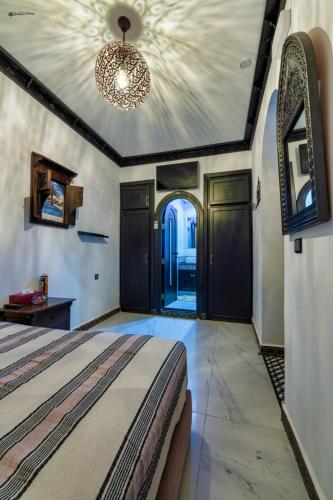 a bedroom with a bed and a chandelier at Riad El Palacio & Spa Chaouen in Chefchaouene