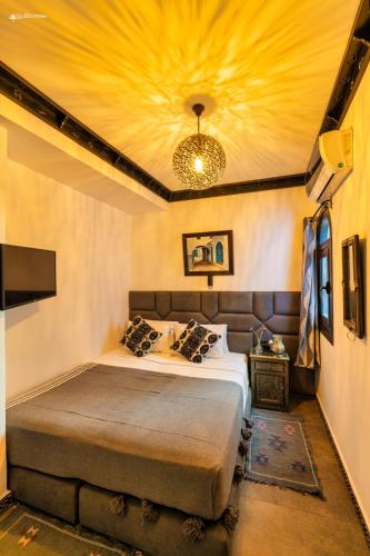 a bedroom with a bed with a yellow ceiling at Riad El Palacio & Spa Chaouen in Chefchaouene