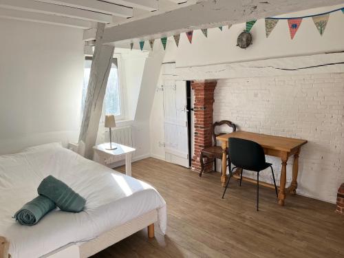 une chambre avec un lit, un bureau et une table dans l'établissement La Vaquerie, à Vatteville