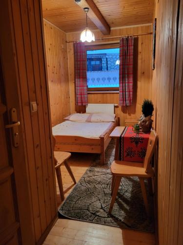 a small room with a bed and a window at Willa Gloria in Zakopane