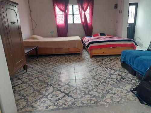 sypialnia z 2 łóżkami i dywanem w obiekcie Habitación muy amplia céntrica cerca de avenidas principales w mieście Aguascalientes