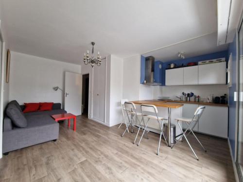 eine Küche und ein Wohnzimmer mit einem Tisch und Stühlen in der Unterkunft Appartement charmant bord de mer in Cabourg