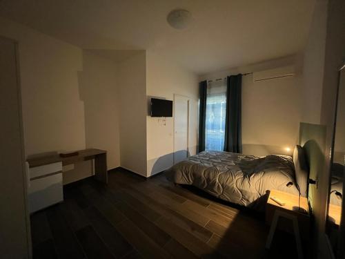 1 dormitorio con cama, escritorio y ventana en B&B ILSE en Capua