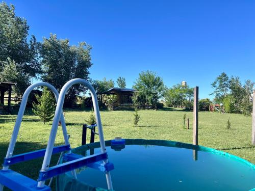 an empty swimming pool in a yard with a field at CABAÑA LA BOHEMIA in Colonia Hughes