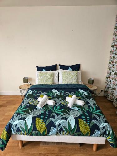 una camera con letto e copriletto blu e verde di studio centre-ville agréable a Vendôme