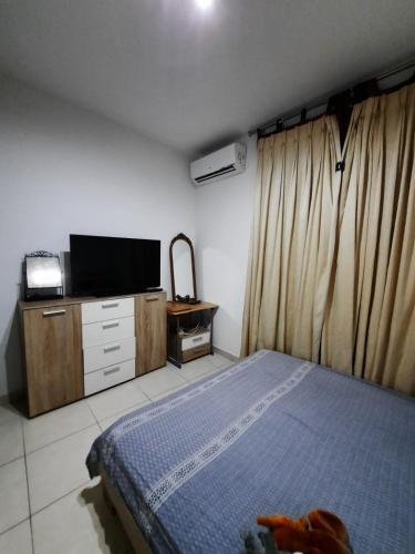 - une chambre avec un lit et une télévision sur une armoire dans l'établissement Lovely Home, à Il-Gżira