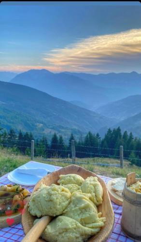 a plate of food on a table with a view of mountains at Čakorski Konaci in Berane