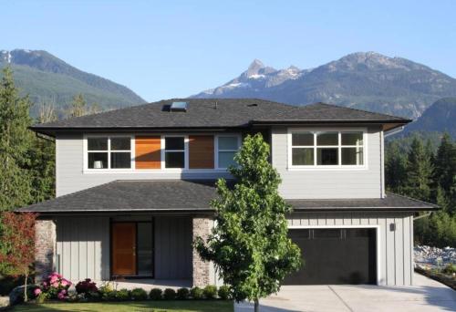 a house with mountains in the background at Mountain Serenity Meets Luxury in Squamish
