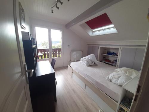 a small bedroom with a bed and a window at Chalet avec vue panoramique sur les Montagnes du Mole et la chaîne des Aravis piscine chauffée à 5 min des pistes de la station des Brasses in Viuz-en-Sallaz