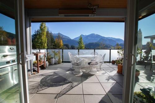 a patio with a table and chairs on a balcony at Mountain Serenity Meets Luxury in Squamish