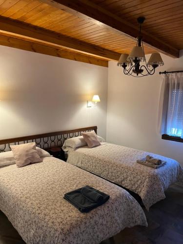 2 Betten in einem Schlafzimmer mit einer schwarzen Tasche darauf in der Unterkunft Casa Rural Torre del Homenaje in Belmonte