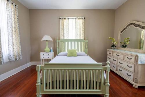 a bedroom with a crib and a dresser at Agatha's Historic Home Free Parking Wi-Fi Deck in Mobile