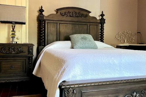 a bedroom with a large bed with a wooden headboard at Agatha's Historic Home Free Parking Wi-Fi Deck in Mobile