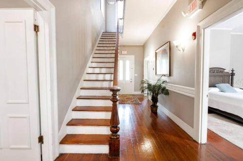 a staircase in a home with white walls and wooden floors at Agatha's Historic Home Free Parking Wi-Fi Deck in Mobile
