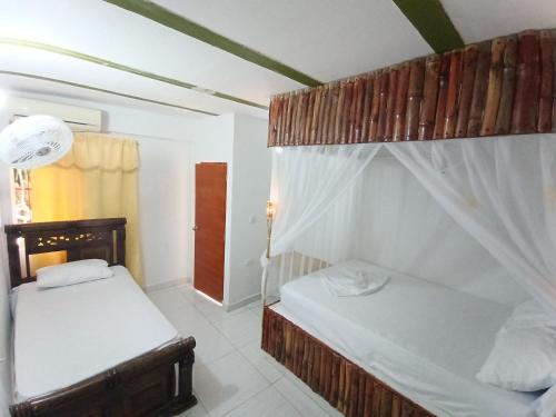 two bunk beds in a room with a window at Hostal Principio Tayrona in Calabazo