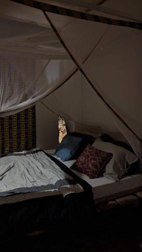 a bed in a tent with two pillows on it at Backyard Hostel in Moshi