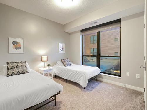 1 dormitorio con 2 camas y ventana en Large Downtown 2br With Parking & Hot Tub, en Des Moines