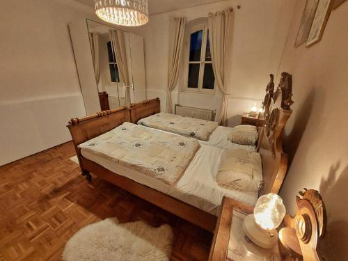 sypialnia z łóżkiem i żyrandolem w obiekcie Wohnen im Grünen w Grazu
