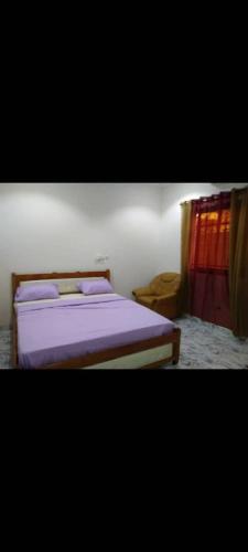 a bedroom with a bed with purple sheets at Sawadogo meublée in Ouagadougou