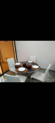 a table with white chairs and a table with plates on it at Sawadogo meublée in Ouagadougou