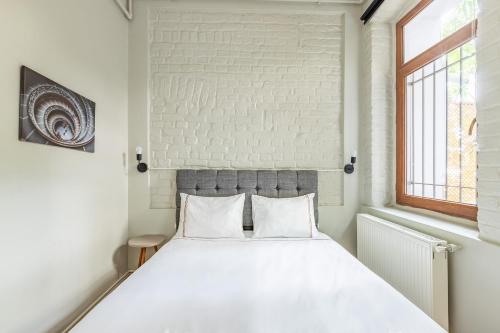 een slaapkamer met een wit bed en een bakstenen muur bij Pin Exclusive 1 BD Taksim A3 in Istanbul