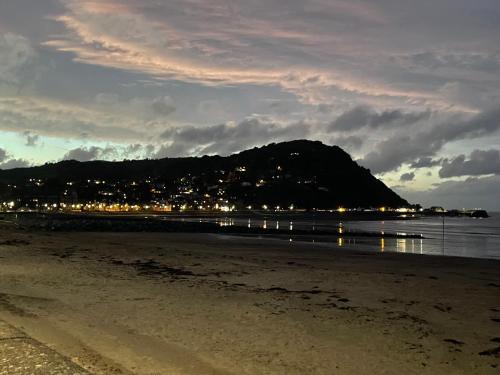 a view of a beach at night with a mountain at Richmond Cottage, Minehead 2 mins to beach in Minehead