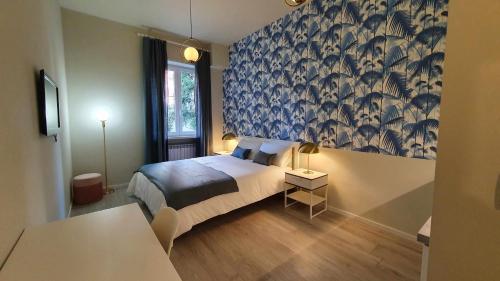 1 dormitorio con 1 cama con papel pintado azul y blanco en Blue Palm Jungle Studio Self Checkin Design, en Milán