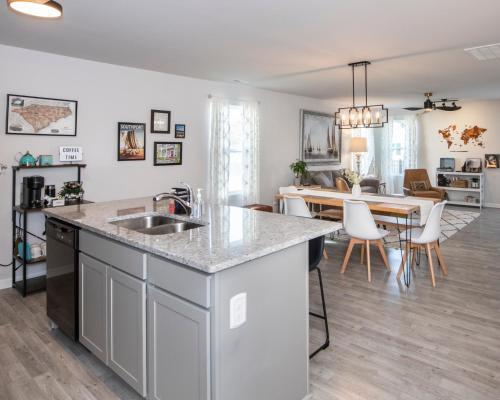 a kitchen and dining room with a kitchen island and a dining table at Cozy Coastal Home Near Beaches, Shops, Restaurants in Southport