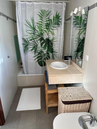 a bathroom with a sink and a shower curtain with a plant at Casa Milan in Puerto Calero