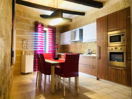 - une cuisine avec une table à manger rouge et des chaises dans l'établissement Authentic House of Character, à Il-Birgu