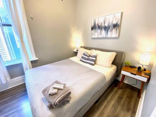 a small bedroom with a bed with towels on it at Spacious Historic Apartments In Lakeview Chicago - Walk to Wrigley, Nightlife, Shops, Hospitals in Chicago