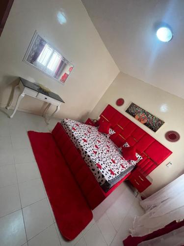 a bedroom with a red bed with red pillows at Luxe et confort a ngor dans un quartier très accessible in Ngor
