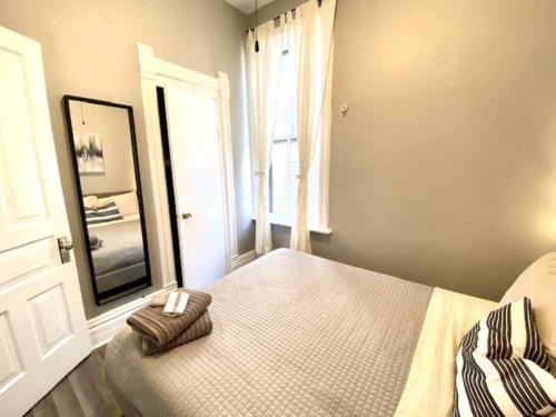 a bedroom with a bed and a large mirror at Spacious Historic Apartments In Lakeview Chicago - Walk to Wrigley, Nightlife, Shops, Hospitals in Chicago