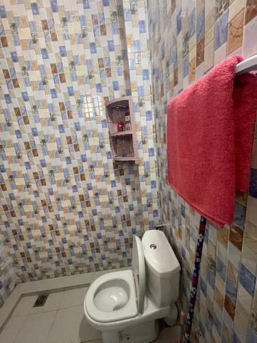 a bathroom with a white toilet and red towels at Luxe et confort a ngor dans un quartier très accessible in Ngor