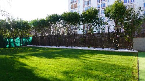 a yard with a fence and green grass at KoalaWakeup in Vitry-sur-Seine