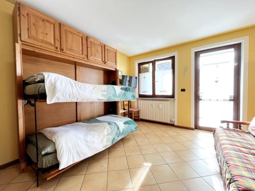 プラート・ネヴォソにあるPlain Soleil ski homeのベッドルーム1室(二段ベッド2台、ソファ付)