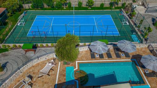 an overhead view of a tennis court with umbrellas at Villa Neveda mit Tennis und Basketballplatz in Datca