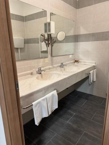 a bathroom with two sinks and a large mirror at Hotel La Torre in Formigine