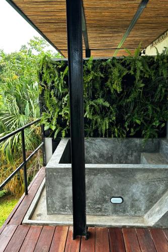 a wooden deck with a bench with plants at Casa Xue Tayrona - Alma Hotels in Los Naranjos