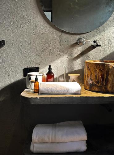 a bathroom with a shelf with towels and a mirror at Casa Xue Tayrona - Alma Hotels in Los Naranjos