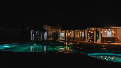 a swimming pool at night with a building at Club Marino Ballena in Uvita
