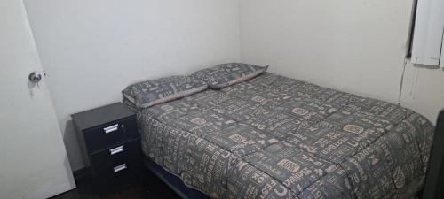 1 cama con edredón y 1 tocador en el dormitorio en Acogedora Habitacion Independiente, en Lima