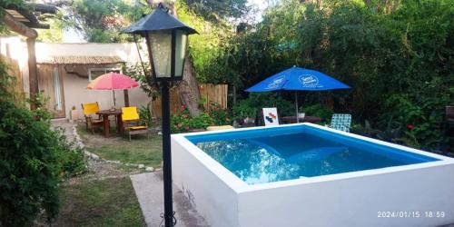 una piscina con sombrilla y luz de la calle en Monoambiente Colibrí en Capilla del Monte