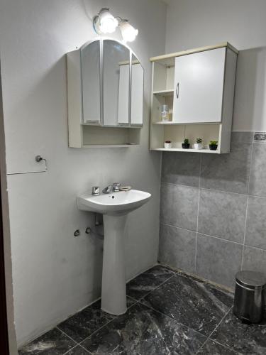 a white bathroom with a sink and a shower at Dpto Beltrán in Santa Rosa