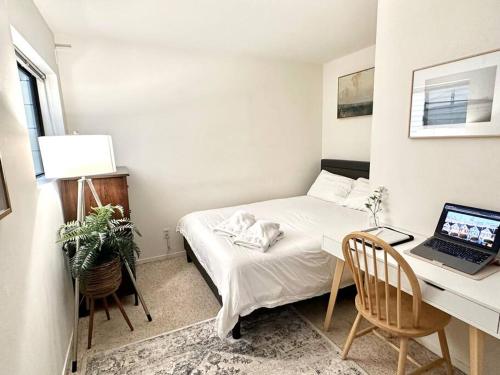una camera da letto con un letto e una scrivania con un computer portatile di Bright Spacious & Comfortable Hayes Valley Condo a San Francisco