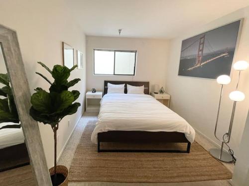 una camera con letto e pianta in vaso di Bright Spacious & Comfortable Hayes Valley Condo a San Francisco