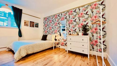a bedroom with a bed and a floral wallpaper at Rest Boutique Portobello in London