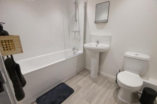 een witte badkamer met een toilet en een wastafel bij Contractors, Medical staff, Relocators, Families- 5 Bedroom 3 bathroom house- 2min walk to L&D in Luton